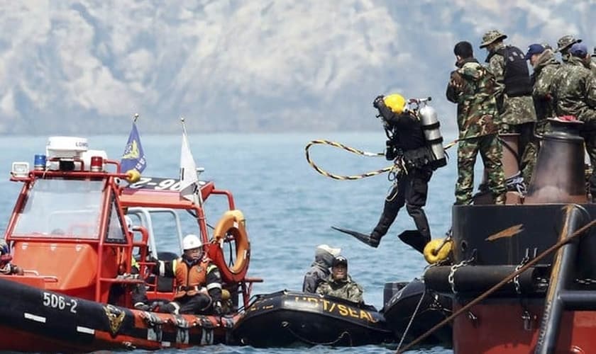 Mergulhador pula no mar na região onde balsa afundou na Coreia do Sul durante trabalhos de resgate das vítimas nesta sexta-feira (25) 