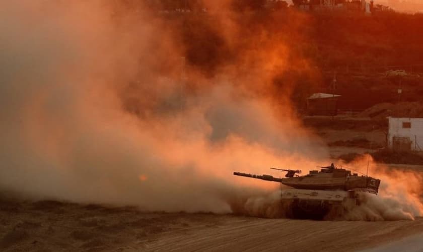 Um tanque israelense volta da Faixa de Gaza para uma base na fronteira israelense