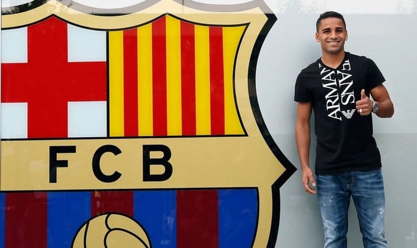 Douglas posa ao lado do escudo do Barcelona