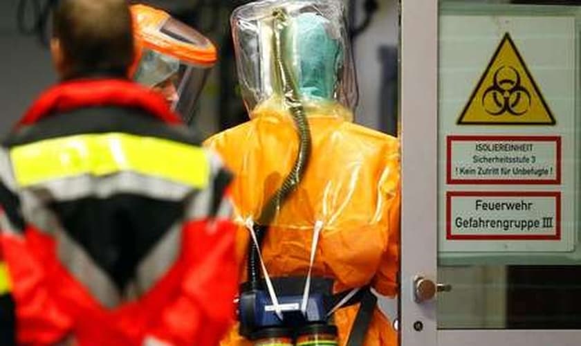 Agentes de saúde vestem roupas especiais para cuidar de pacientes com ebola