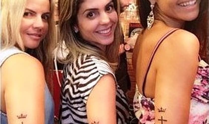Esposa e enteada de Kleber Lucas fazem tatuagem com a marca de sua igreja no braço