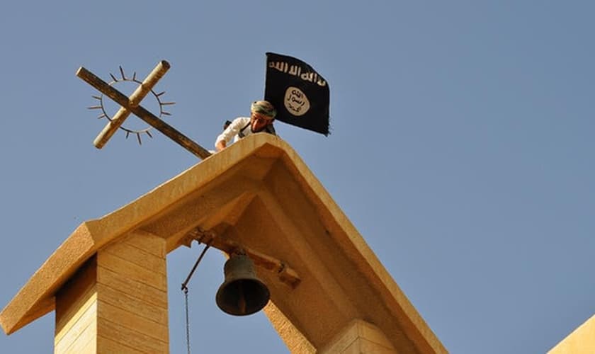 Militante do Estado Islâmico vandaliza igreja cristã, retirando cruz de parte de seu edifício