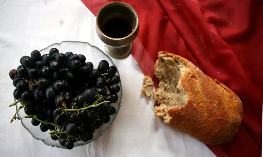 Mesa posta para Páscoa com o cálice, pão e uvas