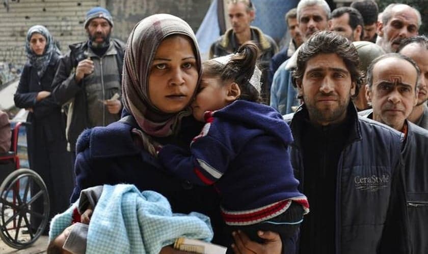 Palestinianos e sírios deixam o campo de refugiados em Yarmouk