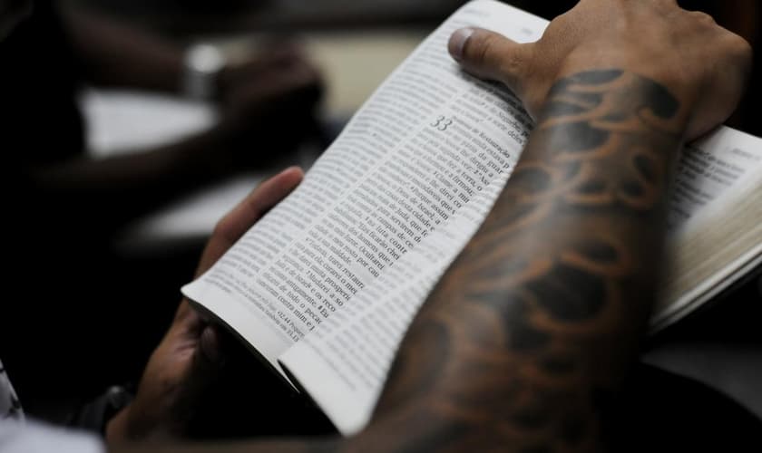 Jovem segurando a Bíblia durante culto em uma igreja evangélica, em São Paulo.  (Foto: Christian Tragni/ Folhapress)