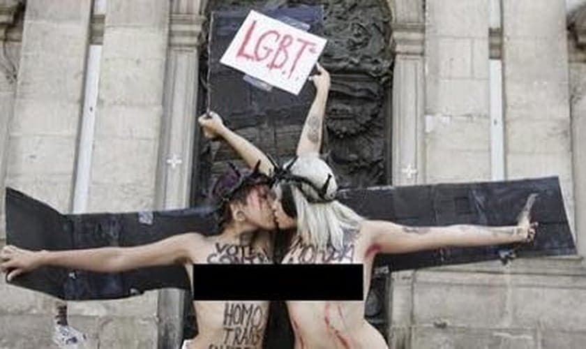 Ativistas se beijam enquanto aparecem 'crucificadas'