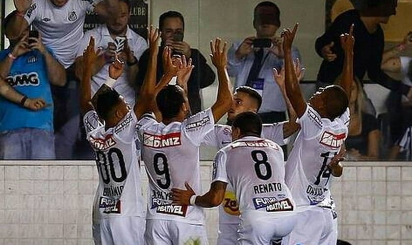Ricardo Oliveira comemora gol com os companheiros de equipe, em atitude de gratidão a Deus.