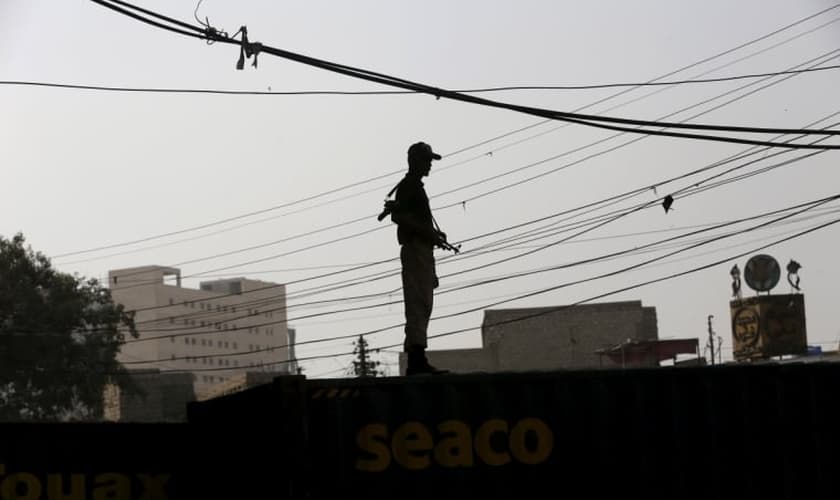 Soldado faz a segurança no terraço de prédio no Paquistão (Foto: Reuters)