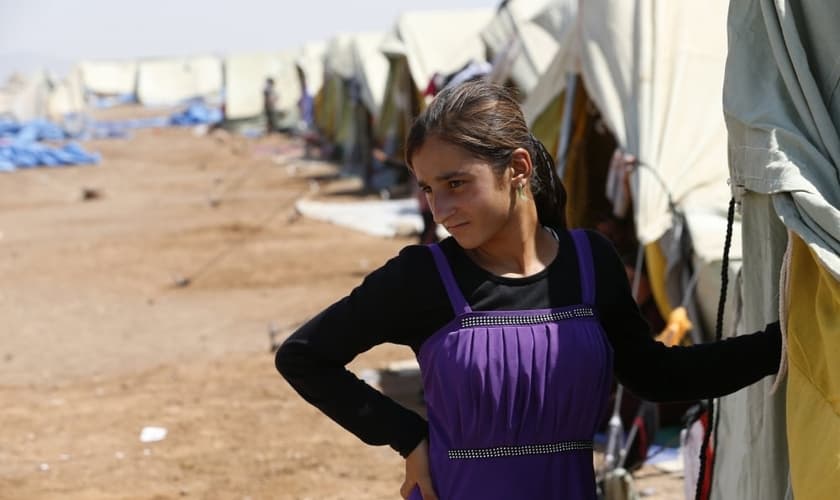 Após conseguir fugir de cativeiro do Estado Islâmico, garota yazidi permanece em frente à sua tenda, em um campo de refugiados na fronteira entre Curdistão e Síria (Foto: Youssef Boudlal / Reuters)
