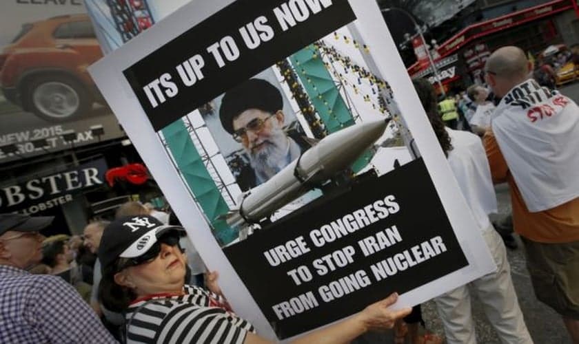 Mulher segura placa em protesto contra o acordo nuclear entre as potências mundias e o Irã. (Foto: Mike Segar / Reuters)