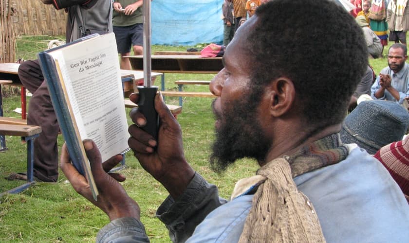 Morador de Papua Nova Guiné lê a Bíblia. (Foto: Joy Ellen)