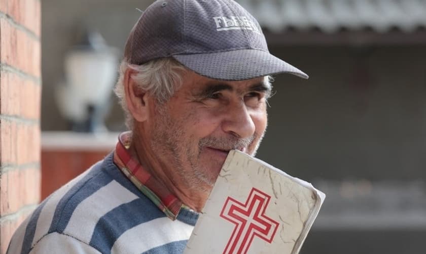Cristão iraniano segura Bíblia nas mãos. (Foto: Sat 7)