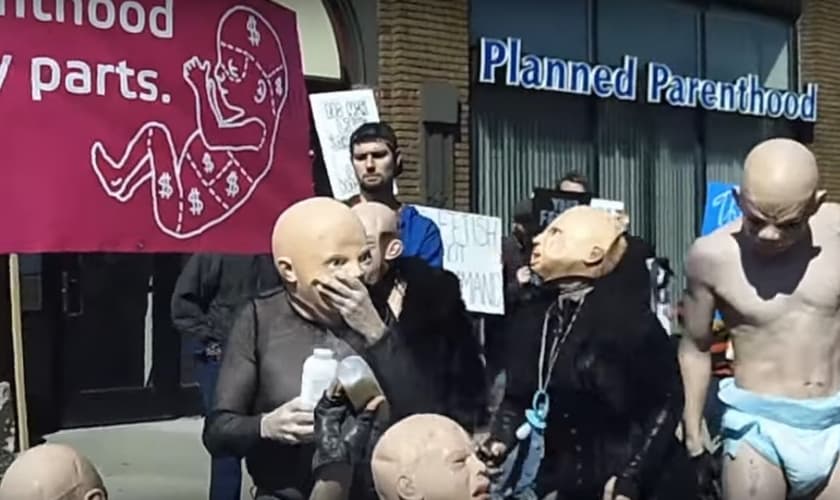 O protesto foi realizado por satanistas que se vestiram de "bebês sadomasoquistas". (Foto: Reprodução/YouTube)