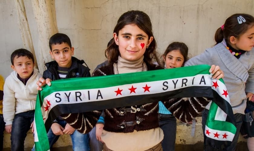 Garota síria posa com faixa inspirada na bandeira de seu país. (Foto: Crossmap)