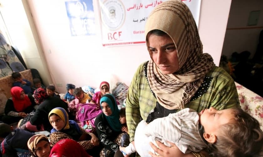 Refugiada carrega seu bebê nos braços. Imagens da vítima citada na matéria não foram divulgadas por razões de segurança. (Foto: Reuters)