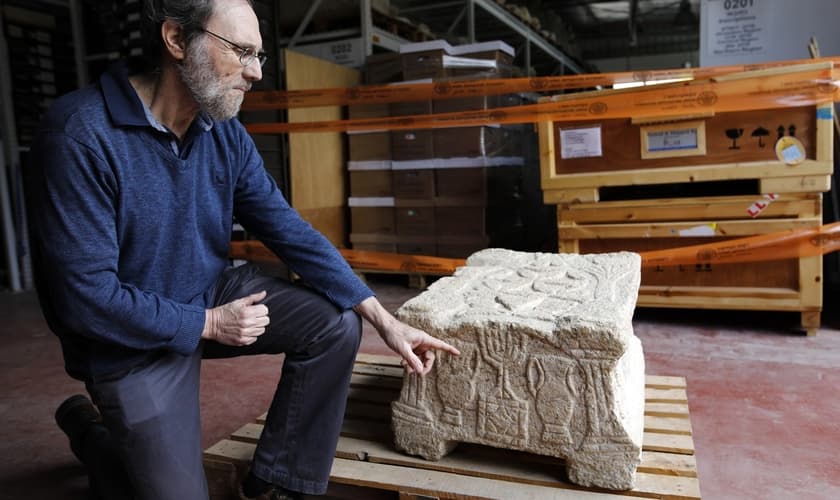 Gideon Avni, diretor da divisão arqueológica da Autoridade de Antiguidades, mostra a Pedra de Madalena. (Foto: Menahem Kahana/AFP)