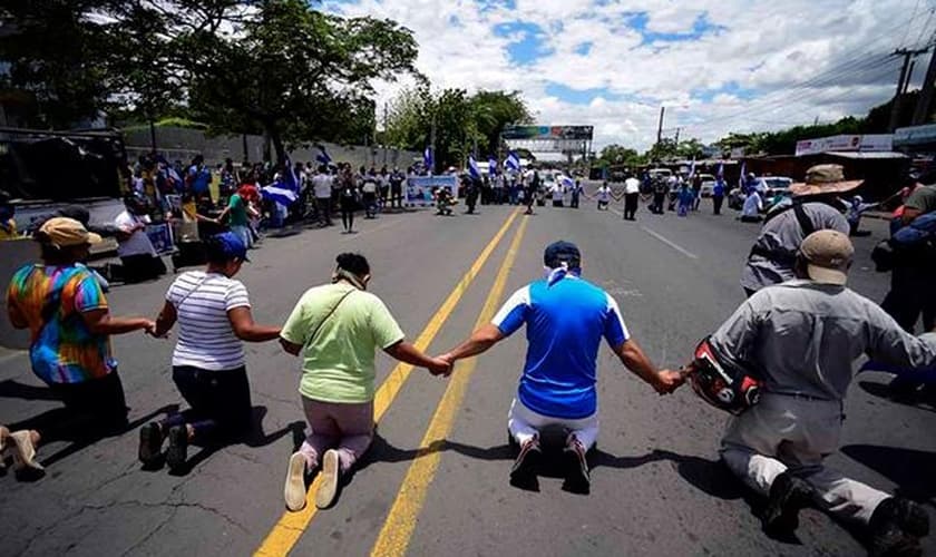 Em manifestação, os cristãos resolveram se ajoelhar e clamar a Deus para que se normalize a situação do país. (Foto: CBN News).