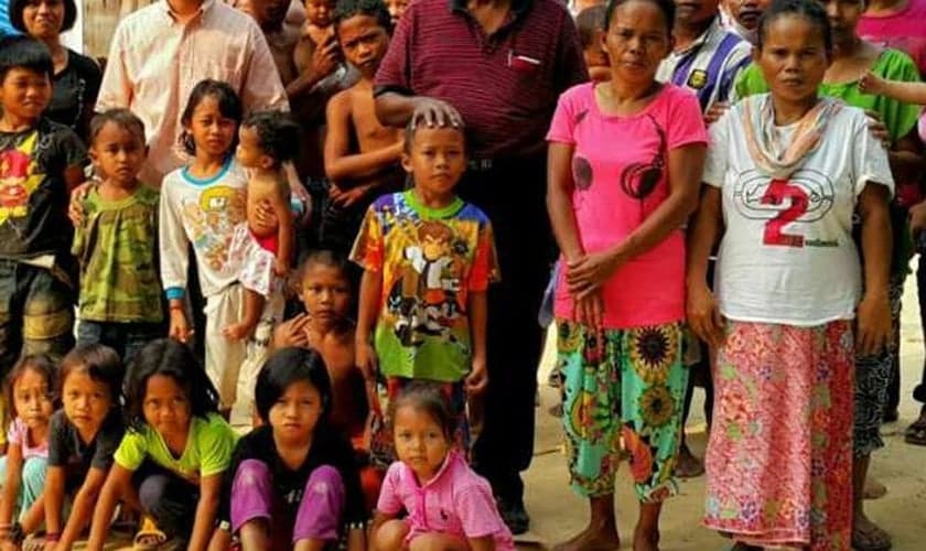 Mark Mathew ao centro de camisa vermelha e os membros da “igreja dos pobres” fundada por ele. (Foto: Reprodução/ Malaysia Today)