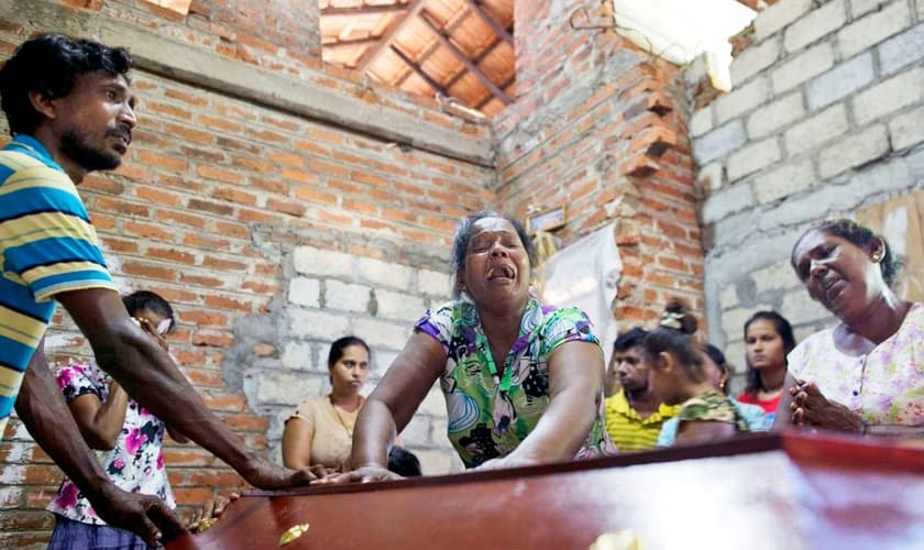 Lalitha chora sobre o caixão da sobrinha de 12 anos, Sneha Savindi, que foi vítima do ataque à igreja de St. Sebastian, no domingo de Páscoa, no Sri Lanka. (Foto: AP Photo/Gemunu Amarasinghe)