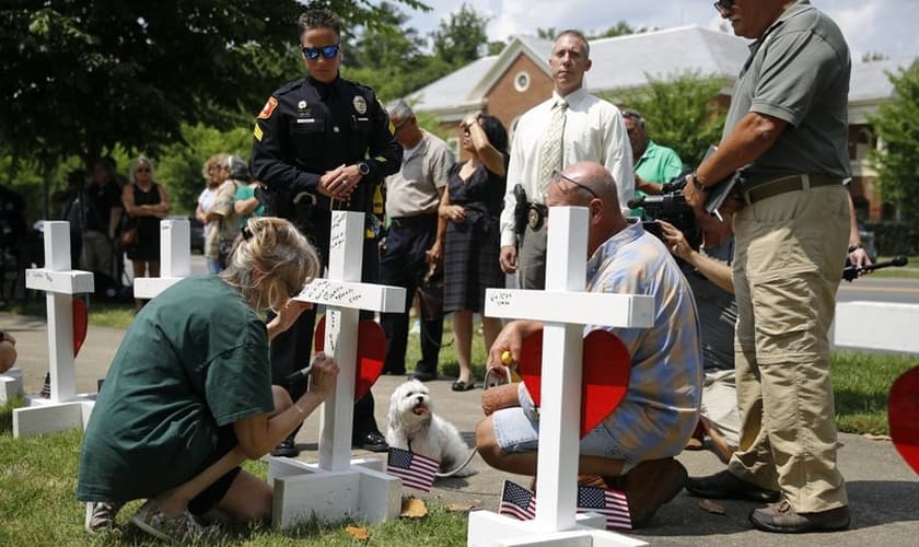 Mulher escreve homenagem para Michelle Langer, uma das vítimas do tiroteio em um prédio municipal de Virginia Beach. (Foto: AP Photo/Patrick Semansky)