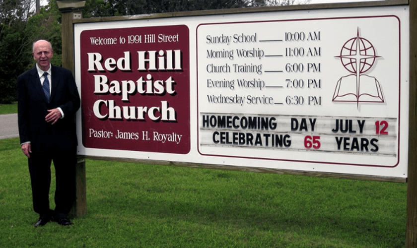 James Royalty ao lado da placa da Igreja com o anúncio de seus 65 anos de pastoreio, em 2015. (Foto: Reprodução/Baptist Red Hill Church)
