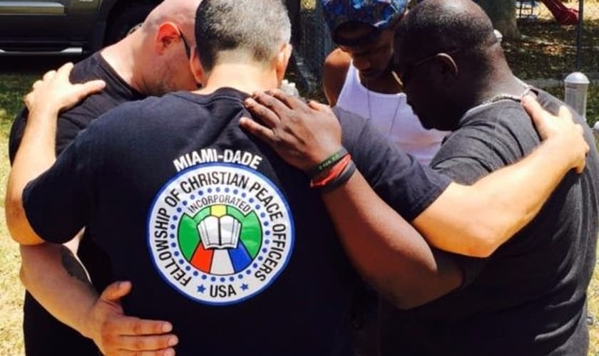 Policiais oram juntos e pelas pessoas nas ruas. (Foto: Reprodução/God Reports)