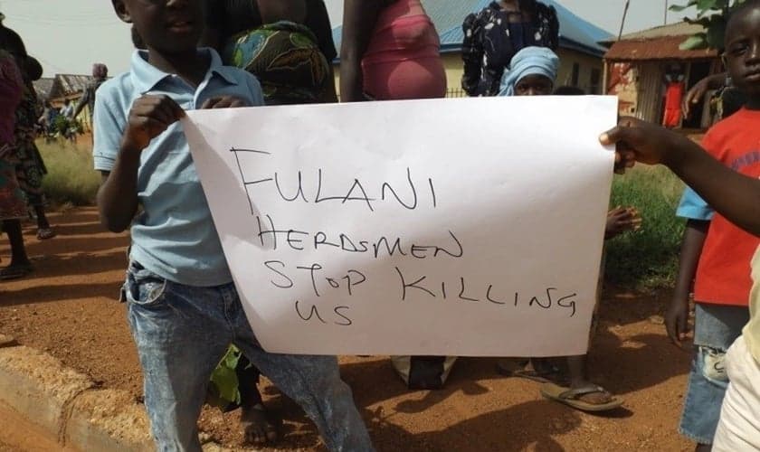 Nigerianos seguram uma placa pedindo o fim dos assassinatos. (Foto: Reprodução / ECCVN)