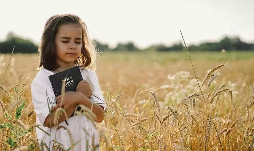 Menina segura sua Bíblia. (Foto: Getty Images / Anastasiia Stiahailo)