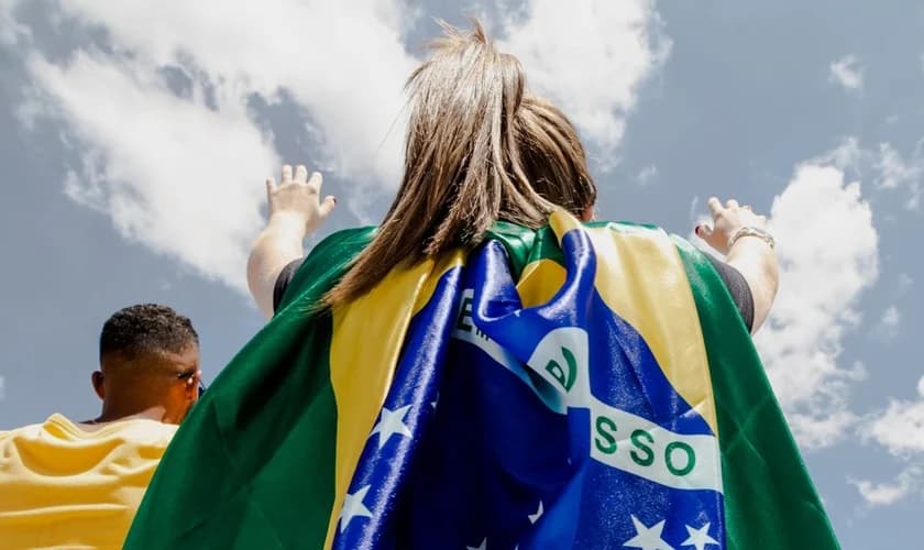 Jovem com bandeira do Brasil em momento de oração, em 8 de fevereiro de 2020. (Foto: Imagem ilustrativa/The Send Brasil).