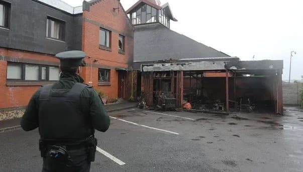 Policial observa igreja incendiada na Irlanda do Norte. (Foto: Reprodução / Bíblia Todo)
