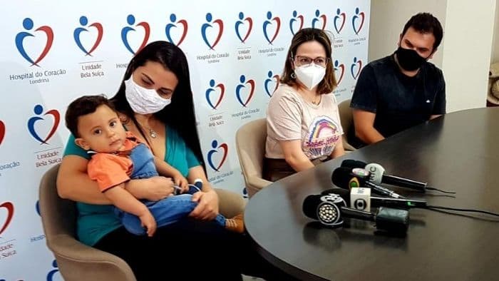 Heitor Araújo nos braços de sua mãe e junto ao pai em entrevista coletiva no dia da alta médica. (Foto: Reprodução / Hospital do Coração)