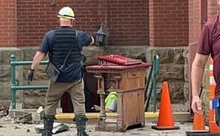 Trabalhadores removem o púlpito ainda intacto dos restos do incêndio. (Foto: Baptist Press)