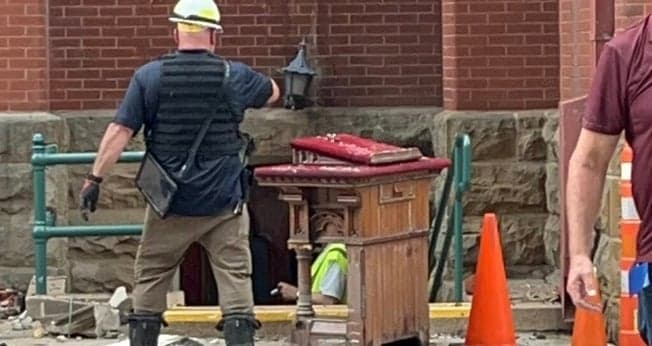 Trabalhadores removem o púlpito ainda intacto dos restos do incêndio. (Foto: Baptist Press)