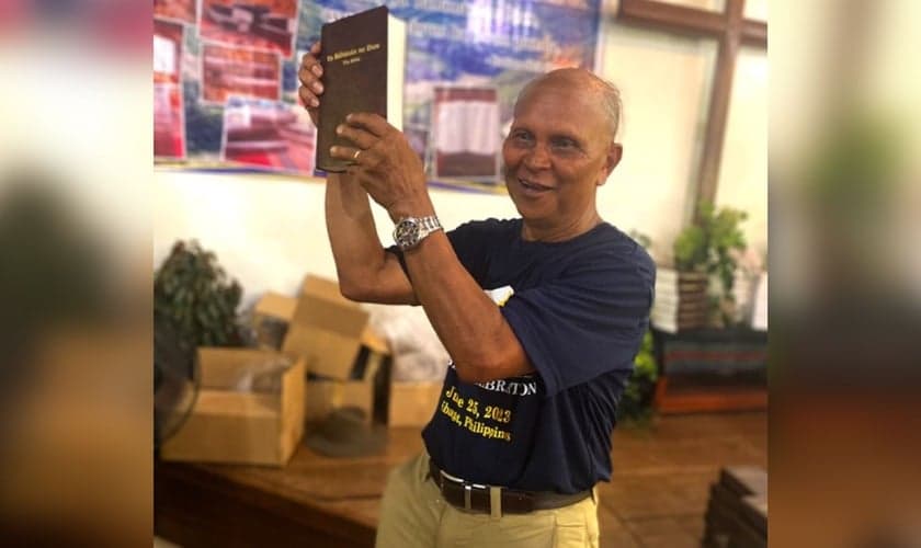 Nard Pugyao segurando a Bíblia no idioma Isnag. (Foto: Wycliffe Bible Translators)