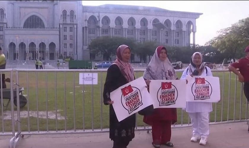 Manifestantes com cartazes em defesa da sharia. (Captura de tela/YouTube/CNA)