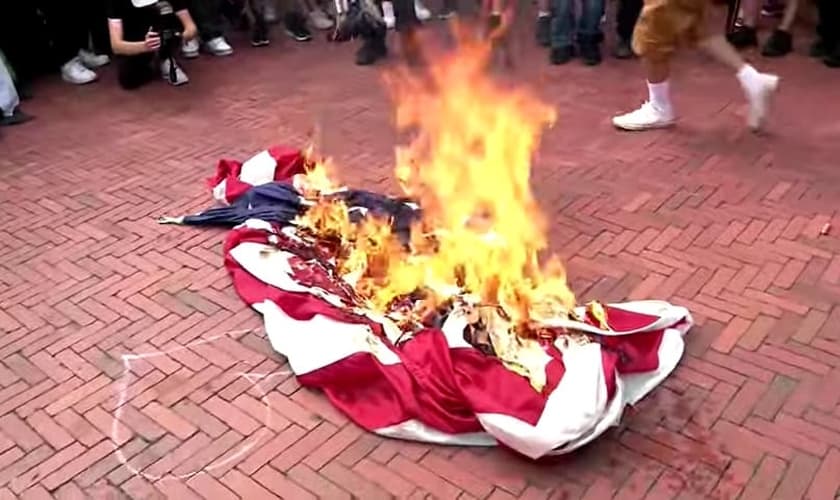 Bandeira americana incendiada em protesto no Capitólio. (Captura de tela/YouTube/The Times and The Sunday Times)