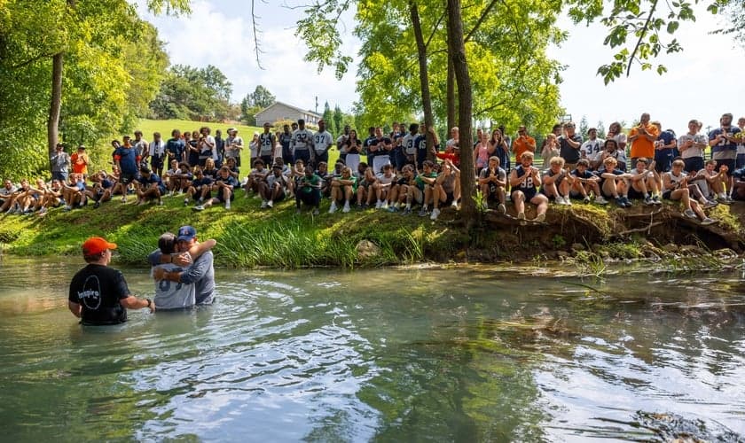 O batismo foi realizado em um riacho. (Foto: X/Carson-Newman University).