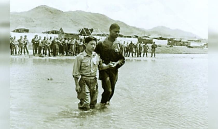 O soldado coreano Lee Hyeong-hwan é batizado pelo capelão Hubert Engram, perto de Seul, em 1952. (Foto: Instituto de História Militar).