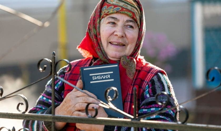 Uma mulher segura uma Bíblia em russo que lhe foi dada por missionários da IMB. (Foto ilustrativa: IMB).