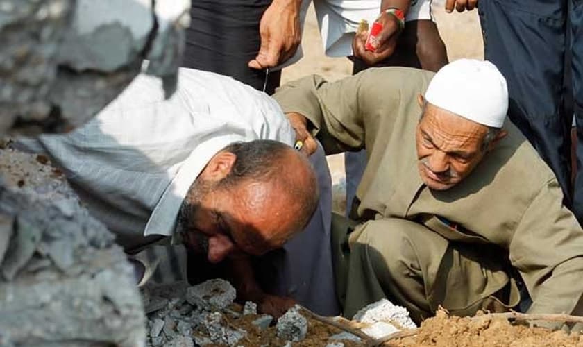 Equipes de resgate palestinas procuram vítimas em um prédio destruído por um ataque aéreo israelense em Rafah.