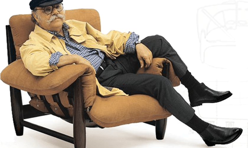 O designer Sergio Rodrigues em uma de suas mais famosas criações, a poltrona Mole, de 1961