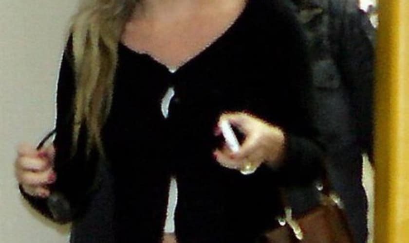 Amanda Mocellin chega à delegacia acompanhada de um PM