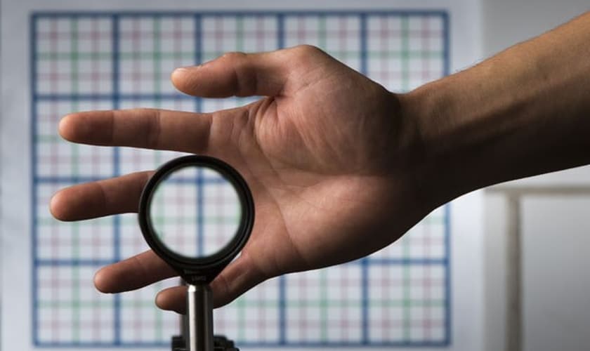 A imagem mostra a mão do estudante Joseph Choi demonstrando o funcionamento das lentes que deixam qualquer coisa invisível