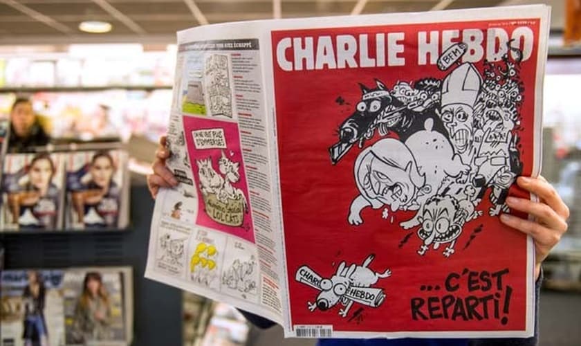 Homem lê a primeira edição do jornal 'Charlie Hebdo' lançada após os ataques de janeiro, nesta quarta-feira (25).