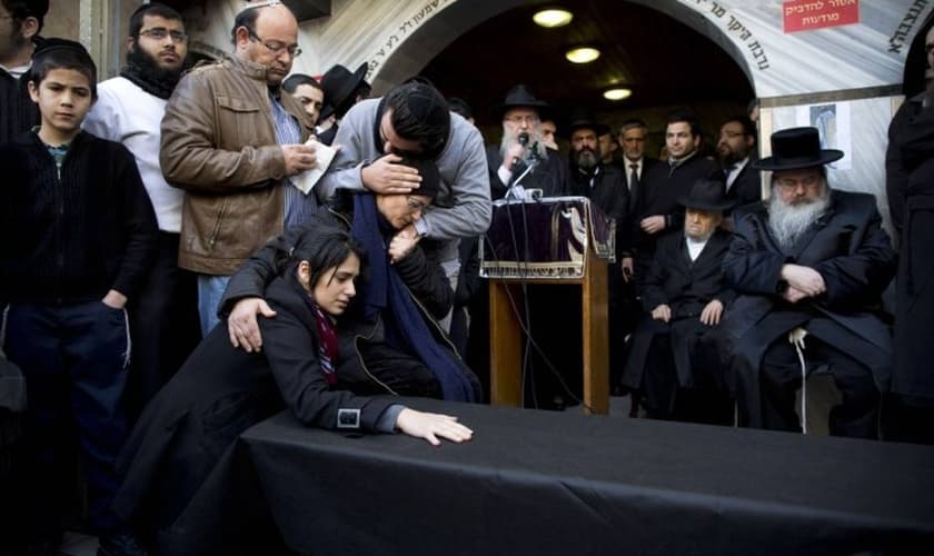 Parente de Yoav Hattab, que morreu no ataque ao Hyper Cacher, recebem o corpo em Bnei Brak, perto de Tel Aviv.