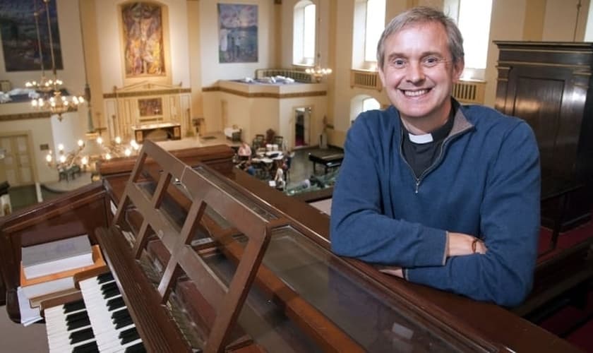 O vigário Canon Godard lidera atualmente a igreja de St. John (Igreja da Inglaterra), em Waterloo (Londres).