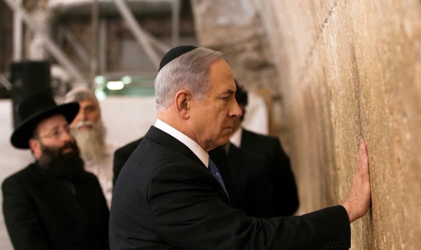 O primeiro-ministro de Israel, Benjamin Netanyahu, toca as pedras do Muro das Lamentações, o lugar do judaísmo mais sagrado para a oração, na Cidade Velha de Jerusalém.