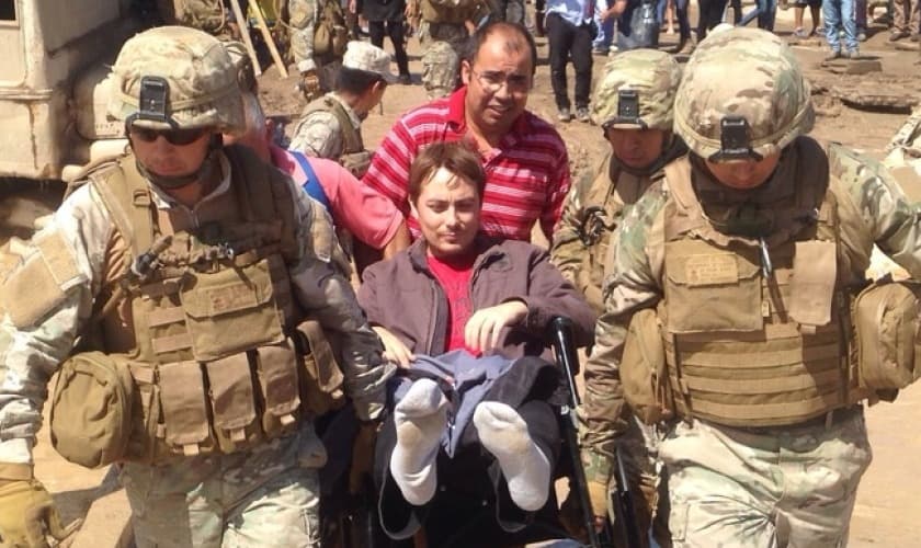 Pastor Rúben sendo carregado por militares.