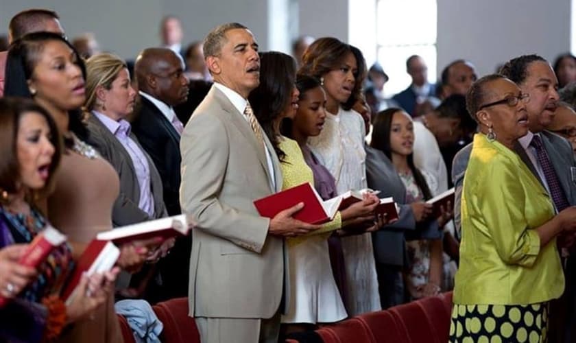 Na imagem, Barack Obama aparece junto à sua família, participando de um culto em meio a outros fiéis.