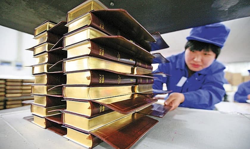 Funcionário da Amity Printing Co. carrega pilhas de Bíblias nas instalações da empresa, em Nanjing, na província de Jiangsu.